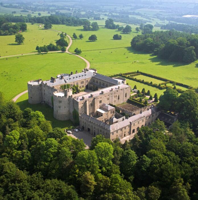 Aerial view of Chirk Castle surrounded by green lawns and trees.