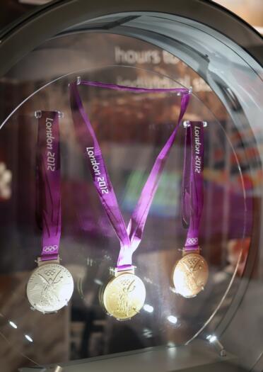 London 2012 Olympic medals on display in a round glass tank.