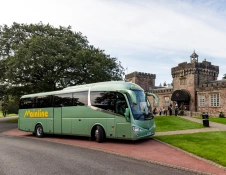 A coach dropping off visitors at a distillery.