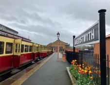 Steam train and carriages at a railway station.
