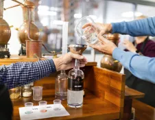 Two people creating their own spirit at a distillery.