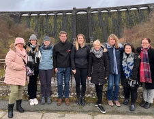 Group of people by a dam smiling for the camera.