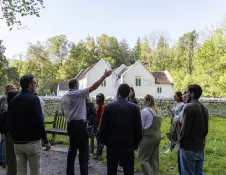 A tour guide showing visitors around an outdoor history museum.