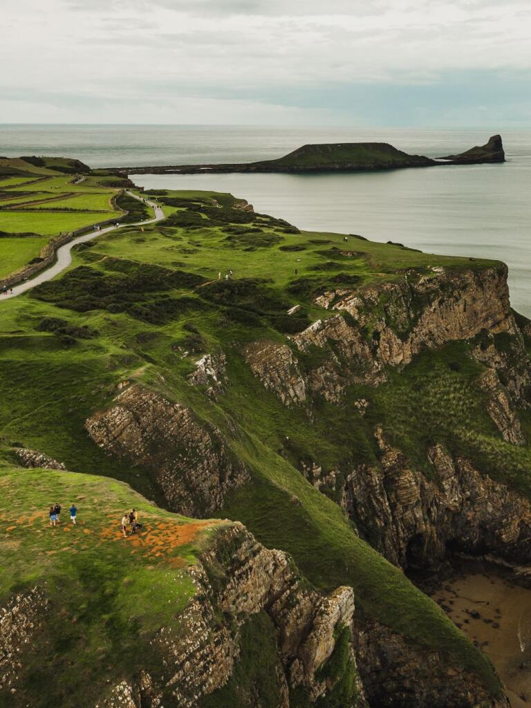 Aerial shot of Rhossili Bay with Worm's Head in the foreground.