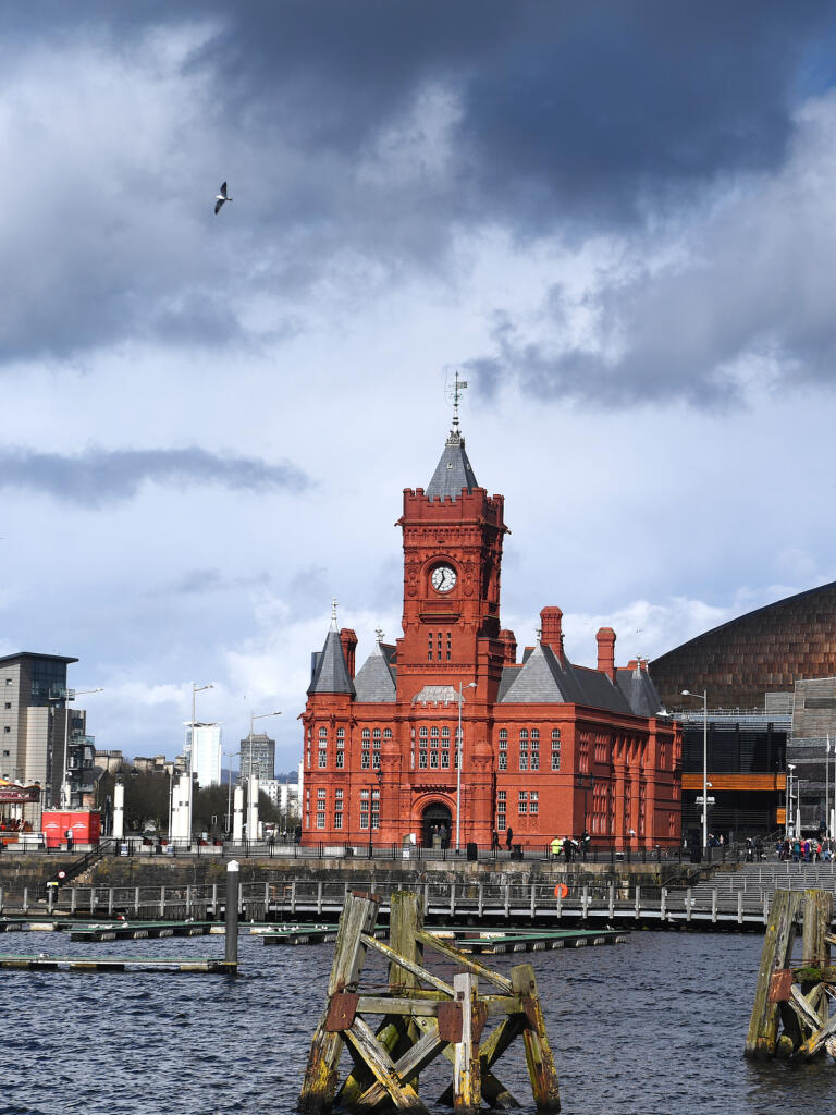 Historic red brick building with clock tower and copper coloured roof building.