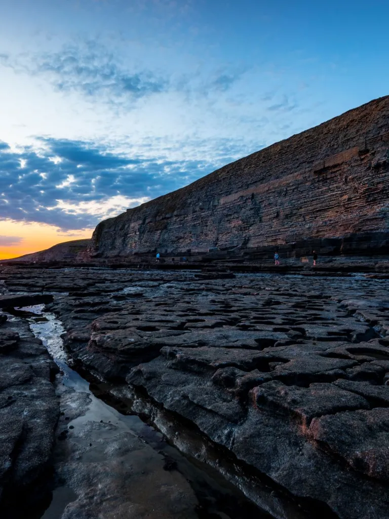 A rocky coastline and cliffs during sunset.