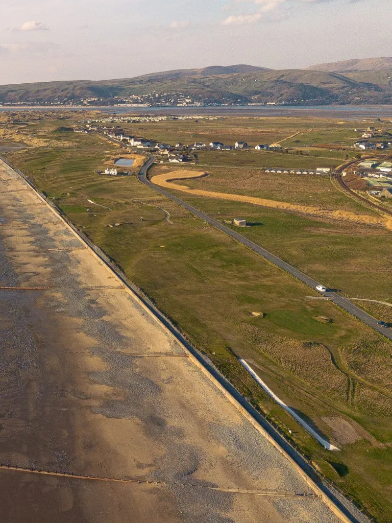 Aerial shot of a golf course alongside a coastline.