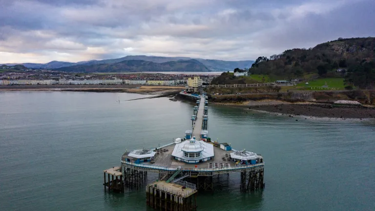 An aerial view of Llandudno Pier and coastline.