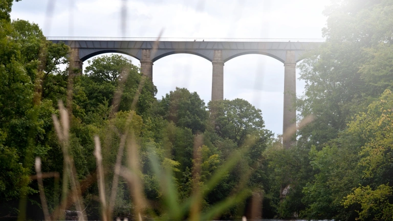 View of a tall aqueduct from the river.