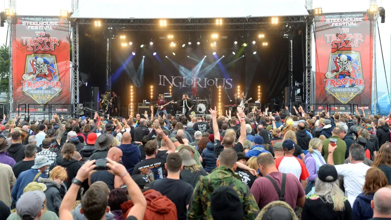 A crowd of music fans enjoying a rock band on stage.