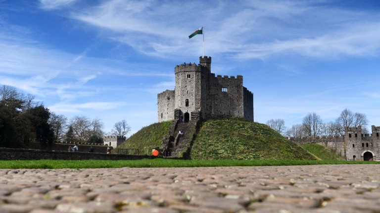 A view of The Keep tower on a grass mound taken from the cobbled footpath,.