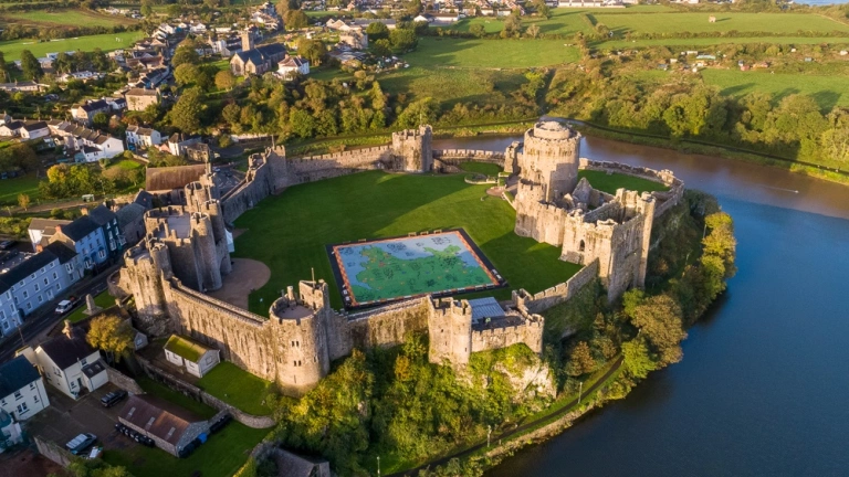 An aerial shot of a castle, town and river.