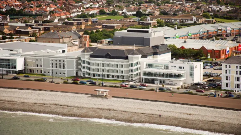 An aerial view of Venue Cymru, Llandudno behind the coastline.