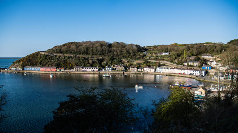 A view of Fishguard town on the coastline beyond the sea.