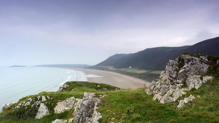 A view from the grassy cliff tops overlooking Rhossili beach.