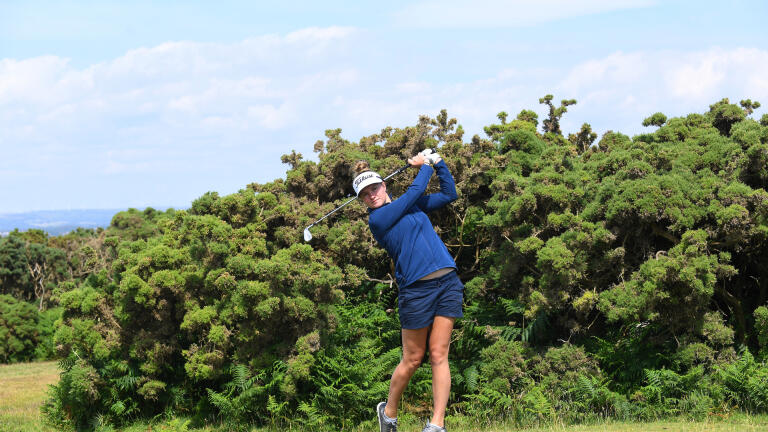 Lady golfer taking a swing at Southerndown Golf Club.