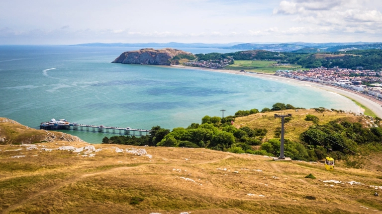 Views of the promenade, coastline, pier and cable cars from a high vantage point.