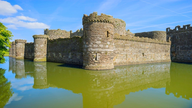 Walls and of a castle by a moat.