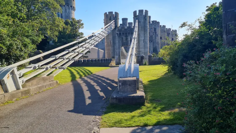 A pedestrian bridge leading to a castle.
