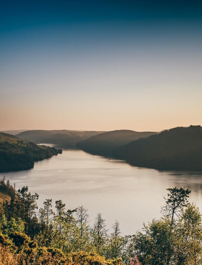 A reservoir surrounded by hills at dusk.