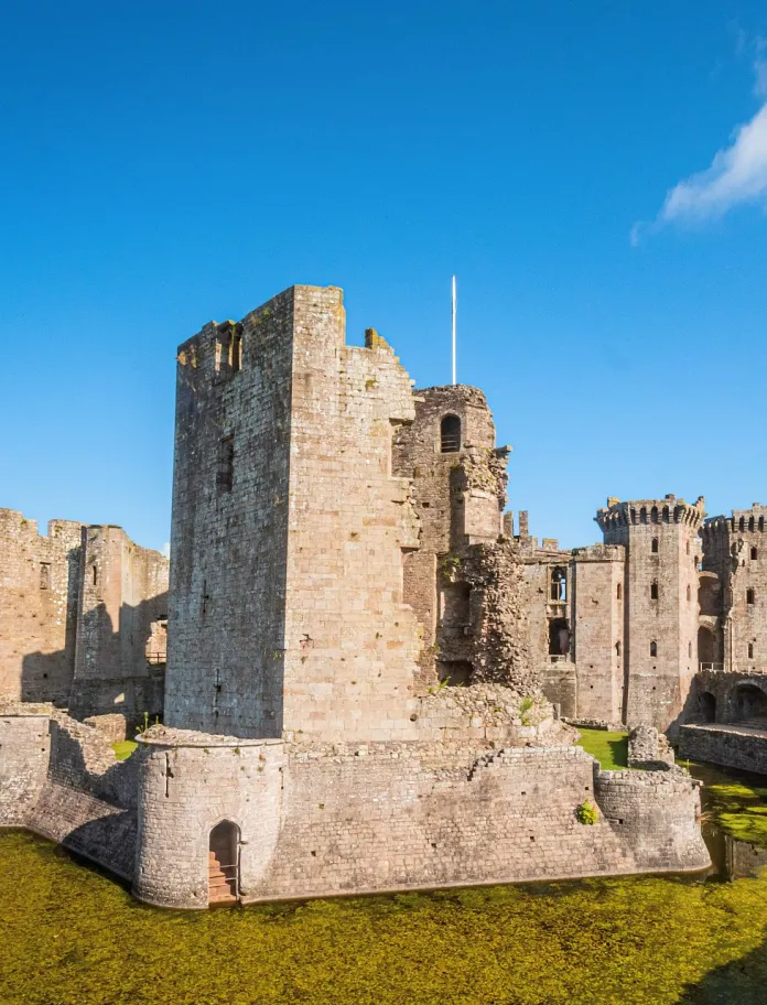 A partially ruined large castle on a moat