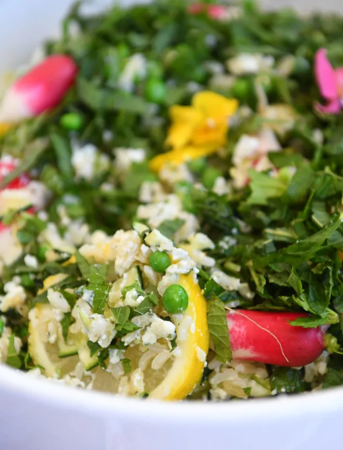 A summer salad of lettuce, peas, radish, edible flowers, lemon and parmesan.