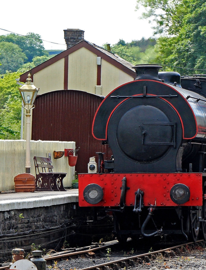 Steam train in station that is decorated with vintage items.