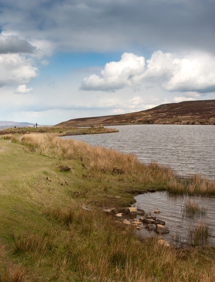A pond with dramatic mountain landscape.