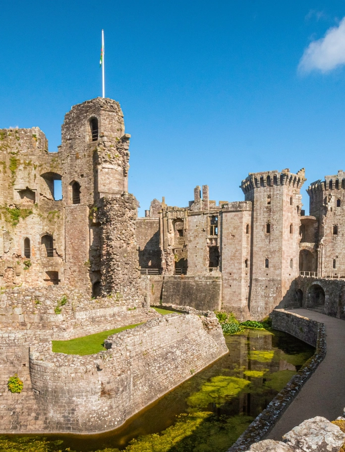 A castle surrounded by a moat on a sunny day.