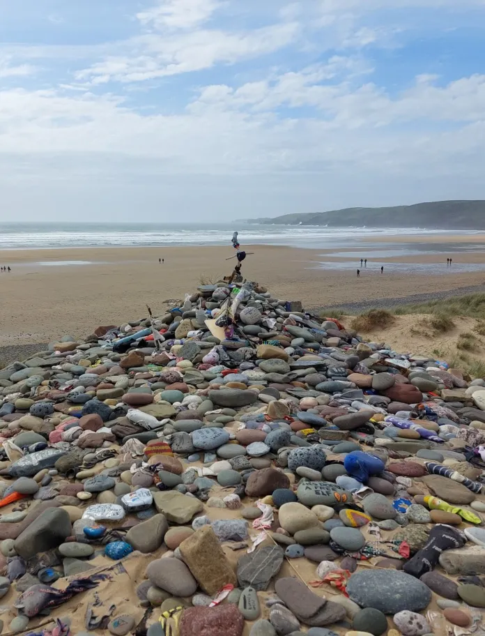 A pile of pebbles on a beach in memorial to Dobbie from Harry Potter.