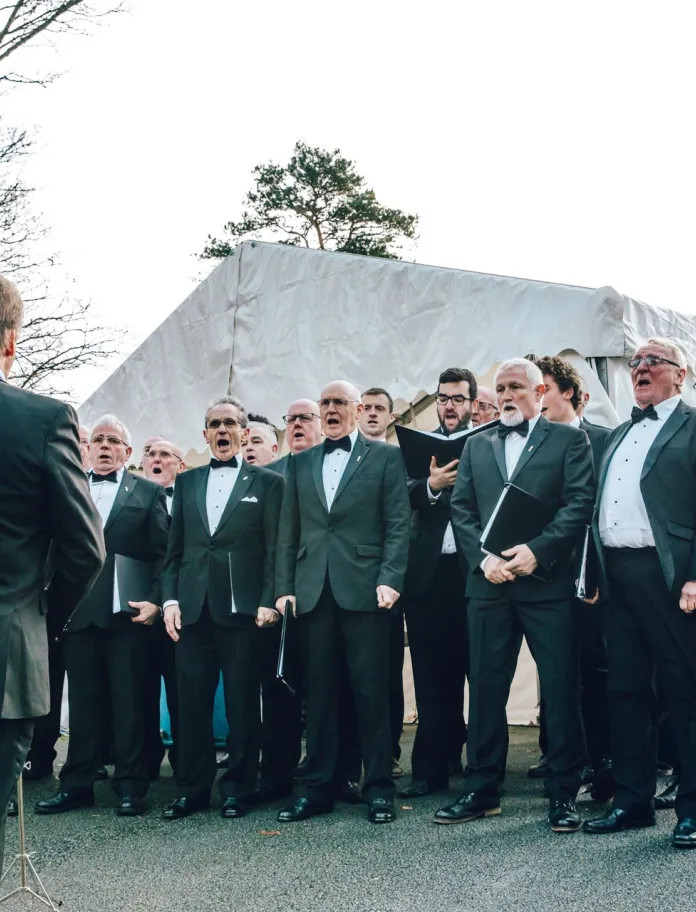 A male voice choir singing at a food festival.