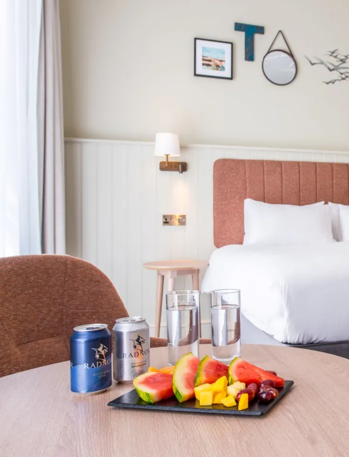 Hotel bedroom with double bed and table with refreshments