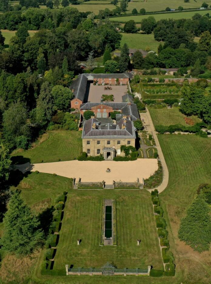 An aerial shot of a manor house and garden surrounded by countryside.