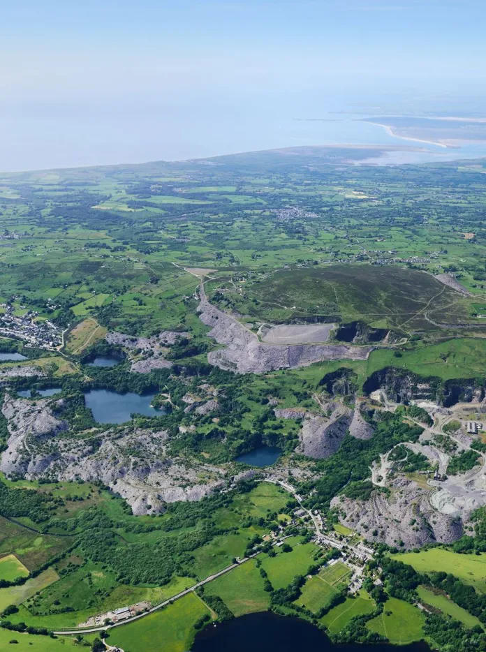 An aerial shot of a slate quarry valley, fields and reservoirs.