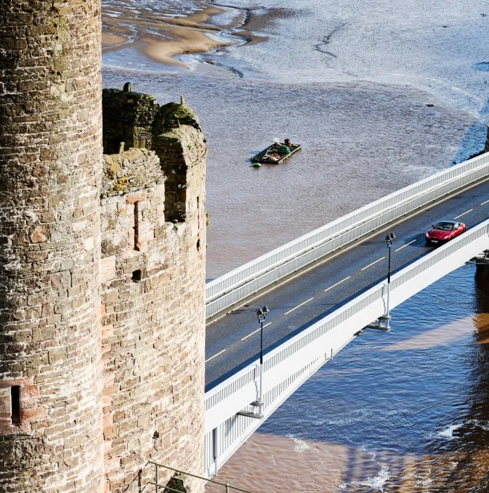 A road bridge going across a harbour, leading to a bridge.