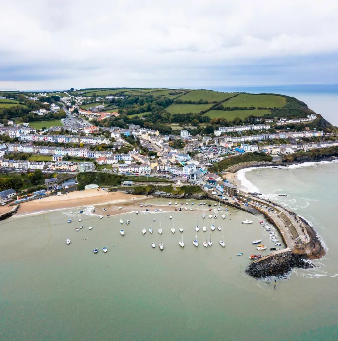 Aerial view of New Quay showing beach, harbour wall and village.