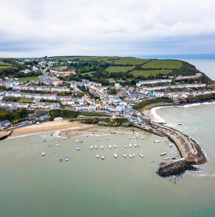 Aerial view of New Quay showing beach, harbour wall and village. 