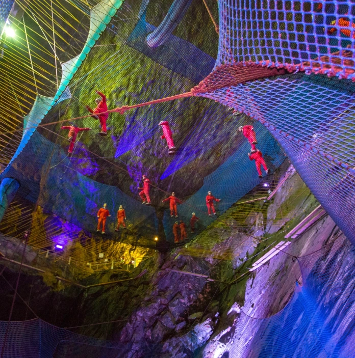 People on bouncing nets in a cavern.