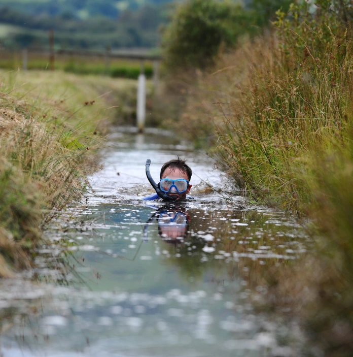 Man in water wearing goggles and a snorkl bog snorkelling.