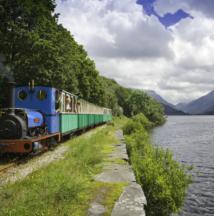 Llanberis Lake Railway steam train travelling alongside the vast lake.