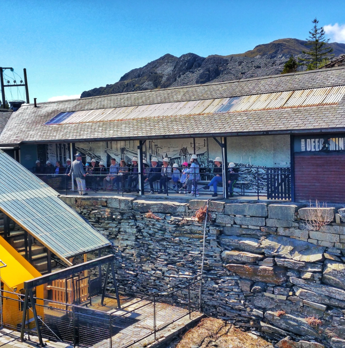 exterior view of cavern with visitors stood looking down 
