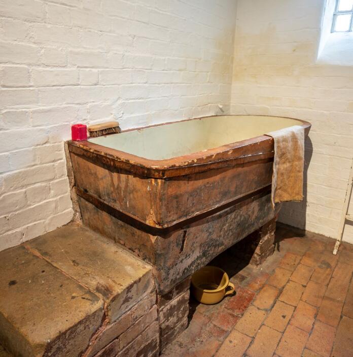 A wooden bath in a jail cell.
