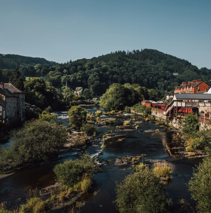 A river running next to a steam train station.