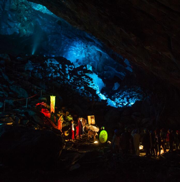 A group of people in a lit up underground cave.
