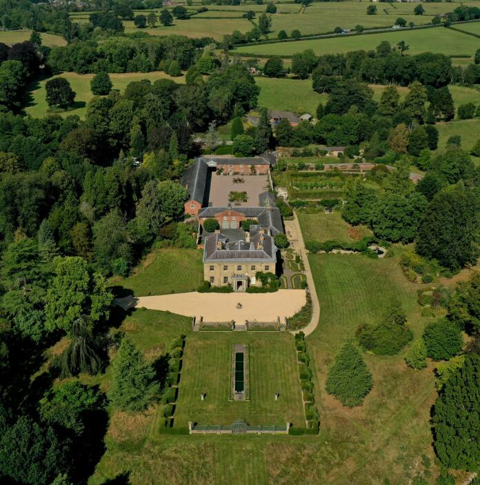 Aerial shot of a grand hall and gardens.