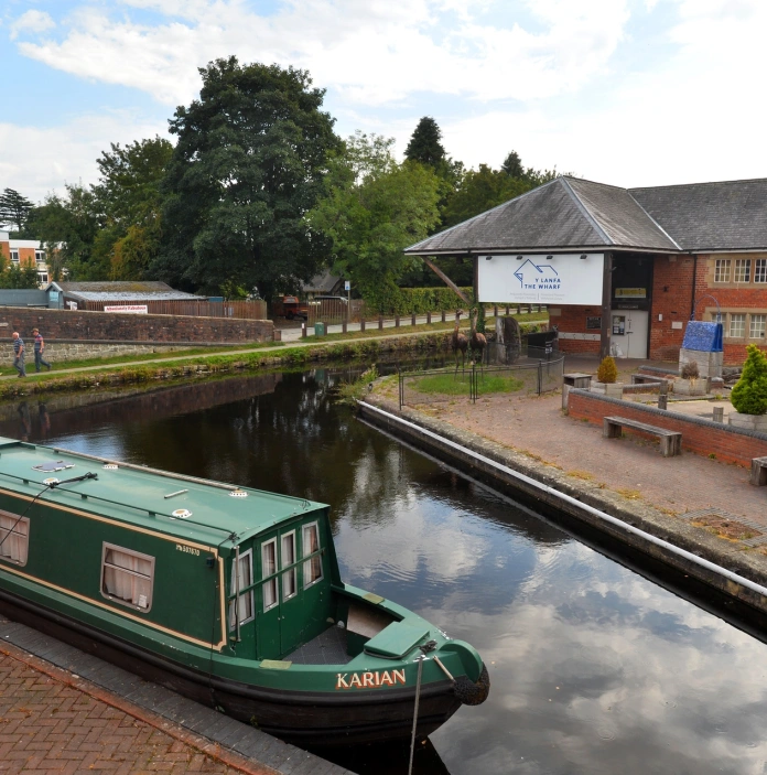 A boat moored up on a canal quayside.
