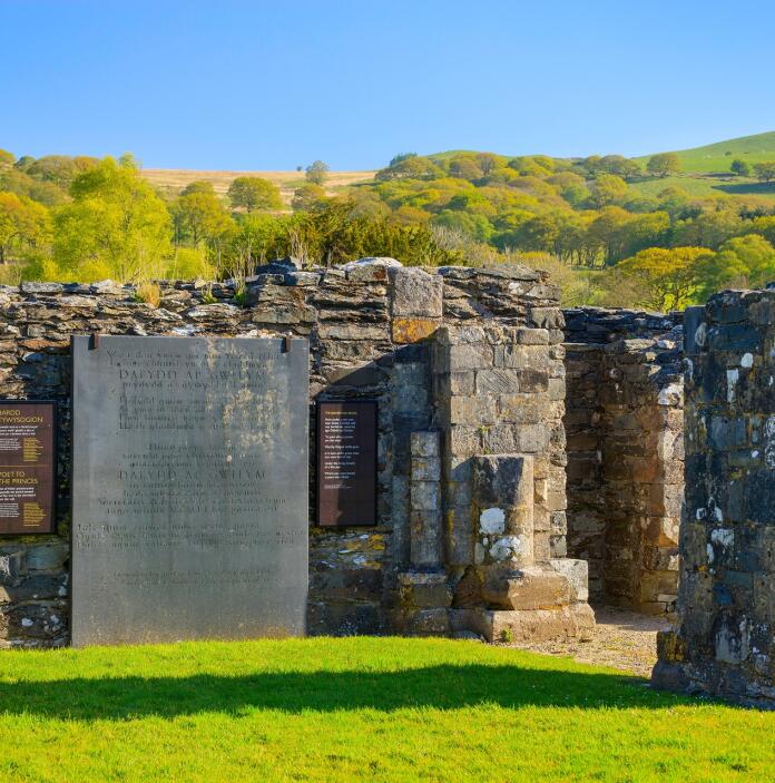 Ruins of an abbey with a slate inscription.