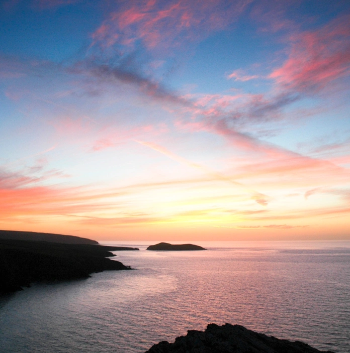 The coastline with a dramatic sky at sunset.