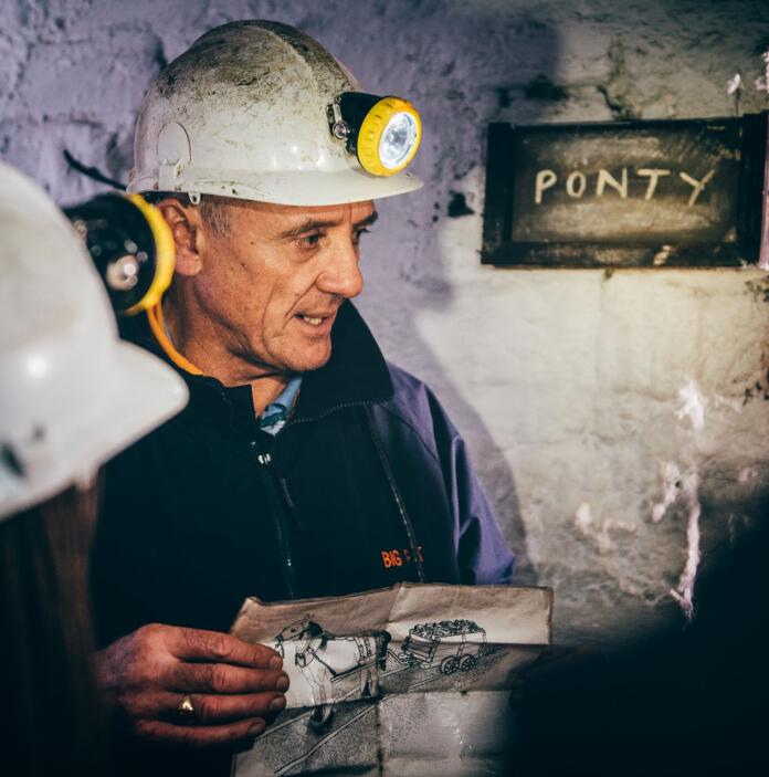 A former miner showing visitors around underground.