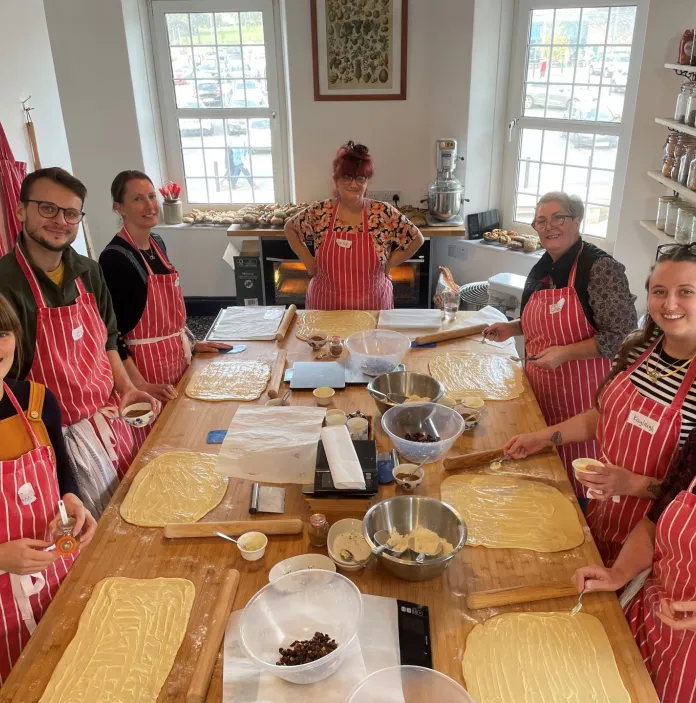 Group of people making bread at a baker school.